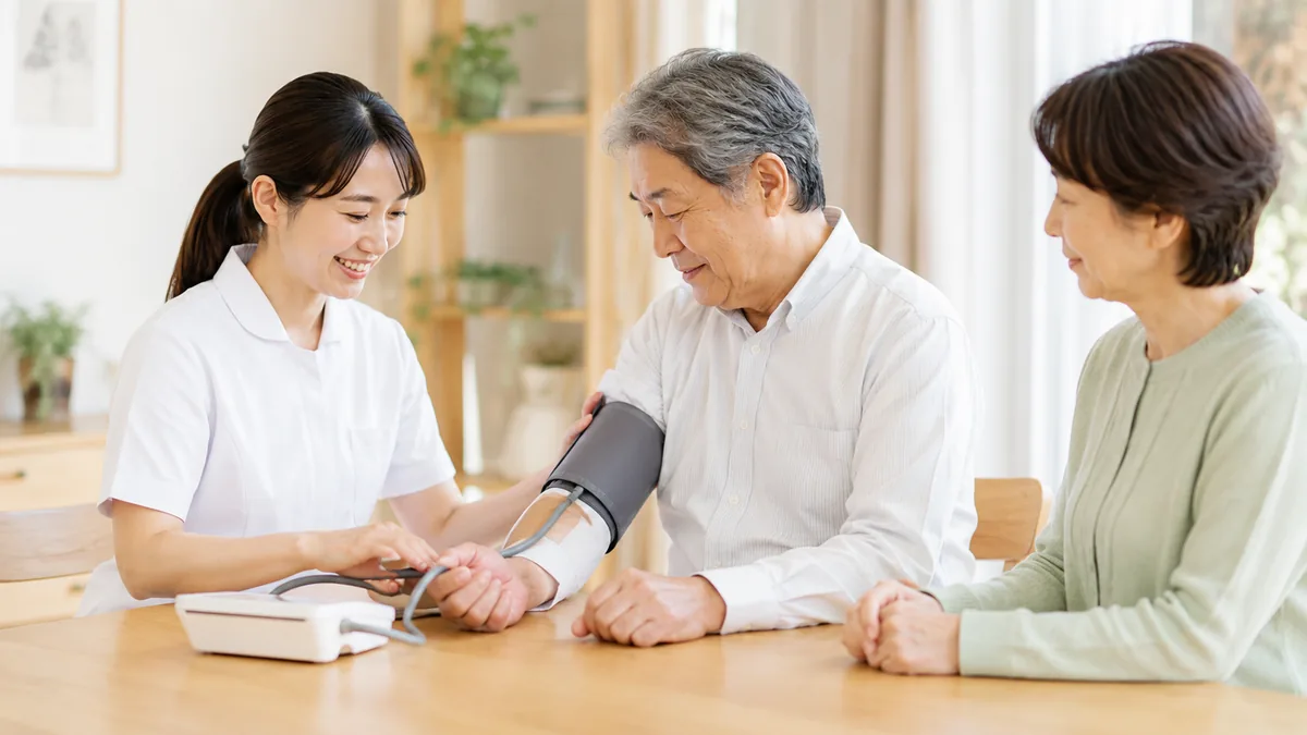 看護師が利用者の体調確認を行い、ご家族も同席している様子